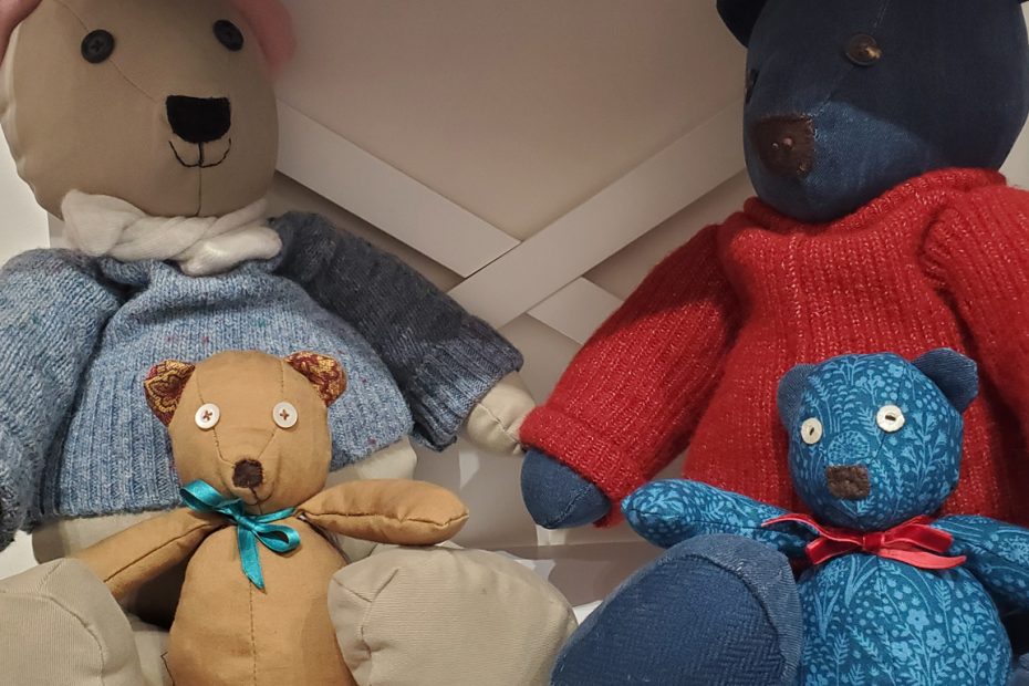 Four handmade bears - 2 large ones behind, with 2 smaller ones in front. The large bears are wearing jumpers.